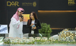 A saleswoman introduces property to potential buyers at the 'Cityscape Qatar 2025' real es...