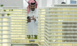 A man visits models of a new building at the 'Cityscape Qatar 2025' real estate exhibition...