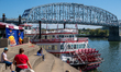 People and paddle boats are seen during America's River Roots Festival on the banks of the...