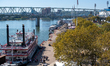 People and paddle boats are seen during America's River Roots Festival on the banks of the...