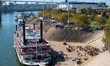People and paddle boats are seen during America's River Roots Festival on the banks of the...