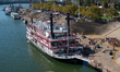 People and paddle boats are seen during America's River Roots Festival on the banks of the...