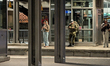 Three people, including a Bundeswehr soldier, use their smartphones while waiting on the p...