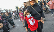 A mother with her teenage son wears a respiratory protection mask and flees after riot pol...