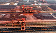 Large-scale machinery stacks and unloads iron ore at the Port of Xinsu in Lianyungang City...
