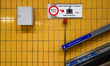 A warning sign instructs passengers to hold onto their luggage during transport on an auto...