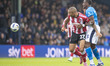 Josh Magennis #27 of Exeter City F.C. is challenged by Joseph Olowu #5 of Stockport County...