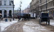 Extras and crew work amidst period-set facades on Krakowskie Przedmieście in Warsaw, Polan...
