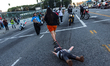 A protester drags a pinata of an ICE agent outside Metropolitan Detention Center following...