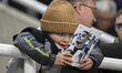 A young fan reads the match programme prior to the UCL League Stage match between Newcastl...