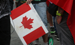 A demonstrator holds a sign with a Canadian flag and the words 'Canada First' during the '...