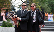 A couple and their dog dress as the Men in Black and pose for a photo during the Washingto...