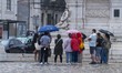 Several people hold umbrellas during a rain shower in Lisbon, Portugal, on October 25, 202...