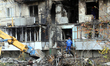 A rescuer stands on the pile of rubble at an apartment block in the Desnianskyi district h...