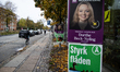 People ride bicycles past election campaign posters for Dorthe Beck-Nyling of the Moderate...