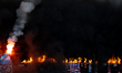 Smoke comes from the stands after Hutnik fans set off flares and burn Wisla scarves during...