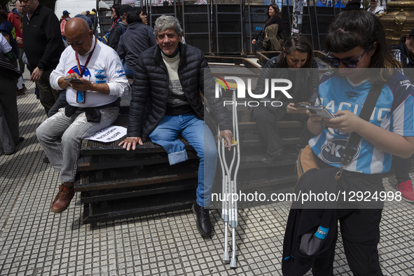 A retired man with one leg uses crutches while sitting on police barriers during a pensioners' protest at the Argentine National Congress. S... by Catriel Gallucci Bordoni/NurPhoto