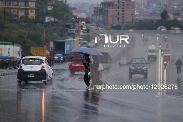 People cross the road in Kathmandu, Nepal, on October 30, 2025, wearing umbrellas as rain batters the national capital under the influence o... by Subaas Shrestha/NurPhoto