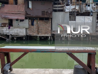 A row of makeshift houses stands precariously above the polluted Duri River at Tanjung Selor Street in Central Jakarta, Indonesia, on Octobe... by Donal Husni/NurPhoto