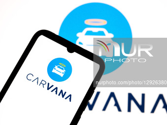 The Carvana logo appears on a smartphone screen and as the background on a laptop computer screen in this photo illustration in Athens, Gree... by Nikolas Kokovlis/NurPhoto
