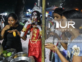A lady dressed in a ghost costume eats a fuchka during a dress-up competition ahead of Halloween in Kolkata, India, on October 30, 2025.  by Debarchan Chatterjee/NurPhoto
