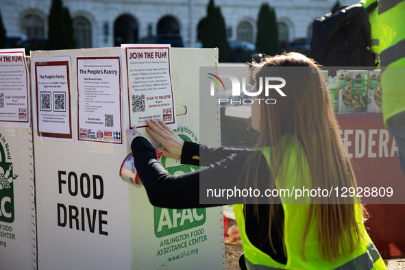 A volunteer posts  a QR code for information about joining the Federal Unionists Netowrk, one of a coalition of organizations hosting a food... by Allison Bailey/NurPhoto