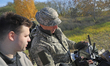 A participant uses a remote control to operate an unmanned ground vehicle (UGV) that carri...