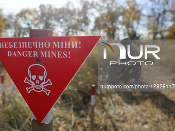 A participant works near a ''Danger, Mines'' sign during humanitarian demining training for war veterans in Kyiv, Ukraine, on October 30, 20... by Yuliia Ovsiannikova/Ukrinform/NurPhoto