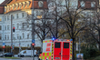 An ambulance with blue flashing lights and ''FEUERWEHR'' and ''NOTARZT'' lettering speeds...