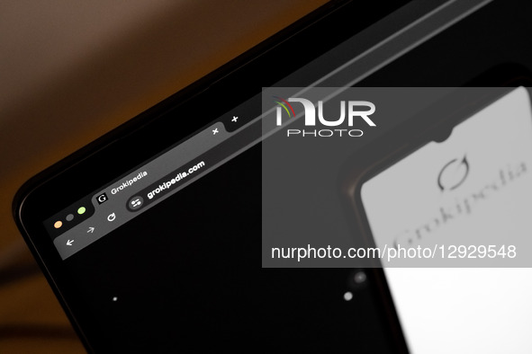 The Grokipedia website appears on a laptop computer screen, and the Grokipedia logo appears on a smartphone screen, in this photo illustrati... by Nikolas Kokovlis/NurPhoto