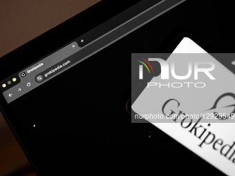 The Grokipedia website appears on a laptop computer screen, and the Grokipedia logo appears on a smartphone screen, in this photo illustrati... by Nikolas Kokovlis/NurPhoto