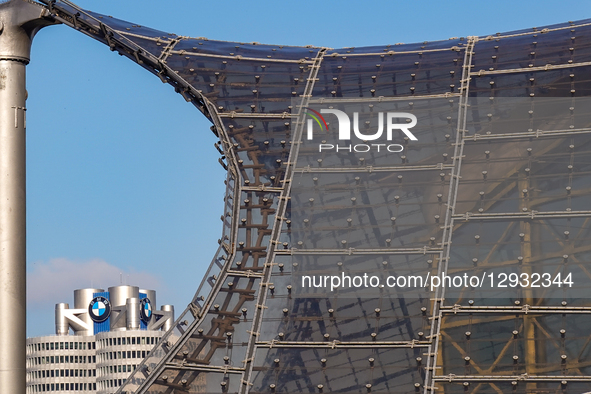 The top of the BMW headquarters tower with the BMW logo and part of the roof structure of the Olympic Stadium is seen in Munich, Bavaria, Ge... by Michael Nguyen/NurPhoto