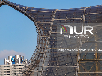 The top of the BMW headquarters tower with the BMW logo and part of the roof structure of the Olympic Stadium is seen in Munich, Bavaria, Ge... by Michael Nguyen/NurPhoto