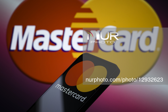The Mastercard logo is displayed on a mobile phone with the company's branding seen in the background in this photo illustration in Brussels... by Jonathan Raa/NurPhoto