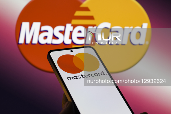 The Mastercard logo is displayed on a mobile phone with the company's branding seen in the background in this photo illustration in Brussels... by Jonathan Raa/NurPhoto