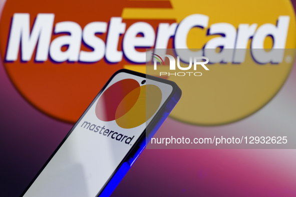 The Mastercard logo is displayed on a mobile phone with the company's branding seen in the background in this photo illustration in Brussels... by Jonathan Raa/NurPhoto