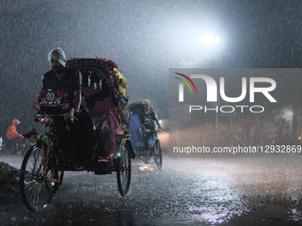 Rickshaw pullers ride through the rain in Dhaka, Bangladesh, on November 1, 2025.  by Syed Mahamudur Rahman/NurPhoto