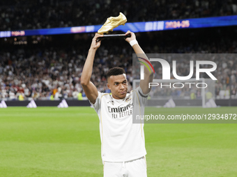 Kylian Mbappe of Real Madrid offers the Golden Boot trophy to Real Madrid fans during the La Liga 2025/26 match between Real Madrid and Vale... by Guillermo Martinez/NurPhoto
