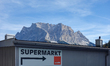 The mighty Zugspitze mountain, Germany's highest peak, towers over the sign of a ''Superma...