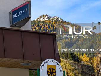 The Polizei (Police) sign displays the Austrian Federal Police emblem and is mounted on a building with the snow-dusted, autumnal Alps tower... by Michael Nguyen/NurPhoto