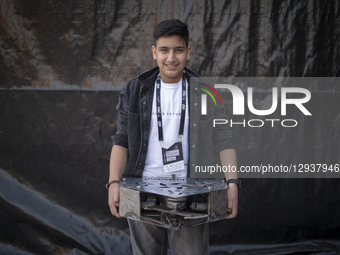 A young Iranian robotics specialist holds his robot as he poses for photographs before participating in the Robot Warriors competition, held... by Morteza Nikoubazl/NurPhoto