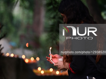 A Christian woman offers prayers over the grave of a family member at the Rajapur Cemetery in Prayagraj, India, on November 2, 2025. All Sou... by Sanjay Kanojia/NurPhoto