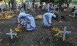 Sisters of Missionaries of Charity light a candle on the lone grave on the eve of All Soul...