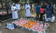 Sisters pray in front of a grave at a cemetery in Kolkata, India, on November 2, 2025, on...