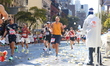 Runner Cody Clark of the USA discards a water cup as he races up First Avenue during the 2...