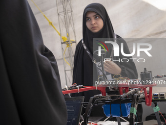 Veiled Iranian drone specialists check their smart drone before participating in a competition during Iran's 2025 Tech Olympics at Pardis Te... by Morteza Nikoubazl/NurPhoto