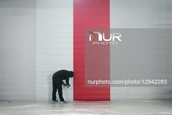 A man is seen working on a set with a Polish flag ahead of the 100th anniversary of the Tomb of the Unknown Soldier on Pilsudskiego Square i... by Jaap Arriens/NurPhoto