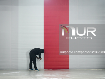 A man is seen working on a set with a Polish flag ahead of the 100th anniversary of the Tomb of the Unknown Soldier on Pilsudskiego Square i... by Jaap Arriens/NurPhoto