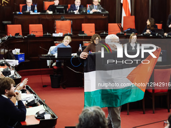 Carlo Monguzzi, a Municipal Councilor, holds a Palestinian flag during the City Council vote on the motion to interrupt the town-twinning wi... by Alessandro Bremec/NurPhoto