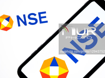 The NSE - National Stock Exchange of India logo appears on a smartphone screen and as the background on a laptop computer screen in this pho... by Nikolas Kokovlis/NurPhoto